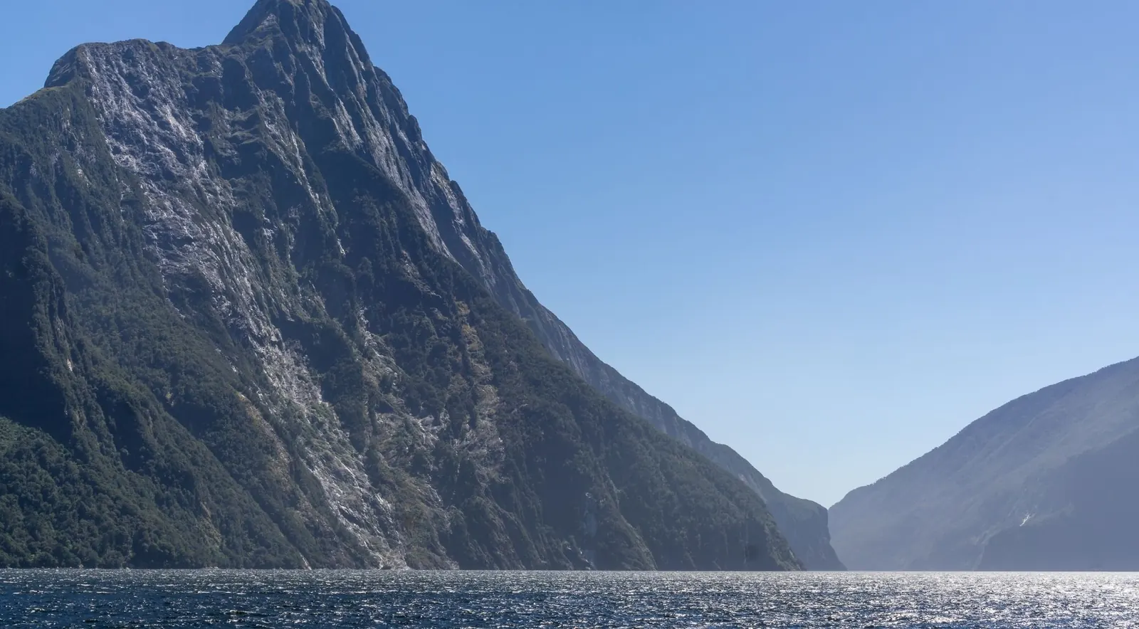 Mitre Peak and the fjord walls of Milford Sound under a clear blue sky